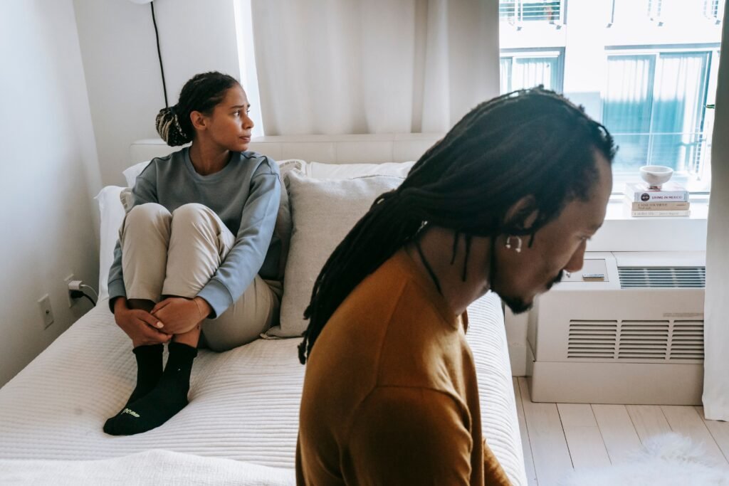 Why do people lose interest when you show interest back? A couple sitting apart, illustrating emotional distance in a relationship.