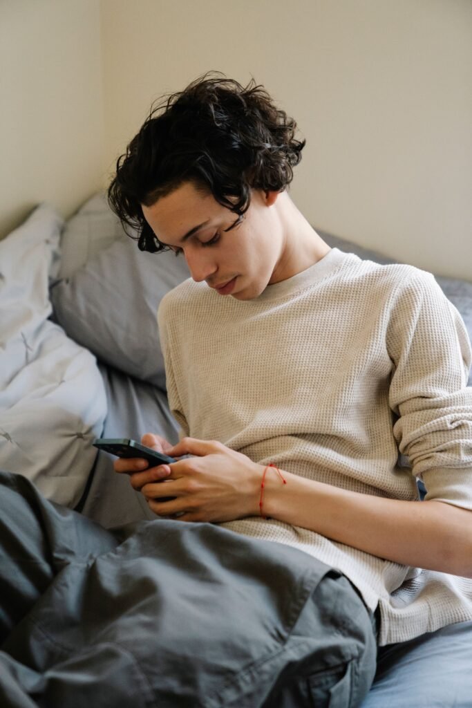 Smartphone resting on a bed, representing uncertainty and waiting for communication in modern dating.